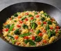 Mørk panne med stekt ris, eggebiter, spinat, brokkoli, rød paprika, gulrot og sukkererter